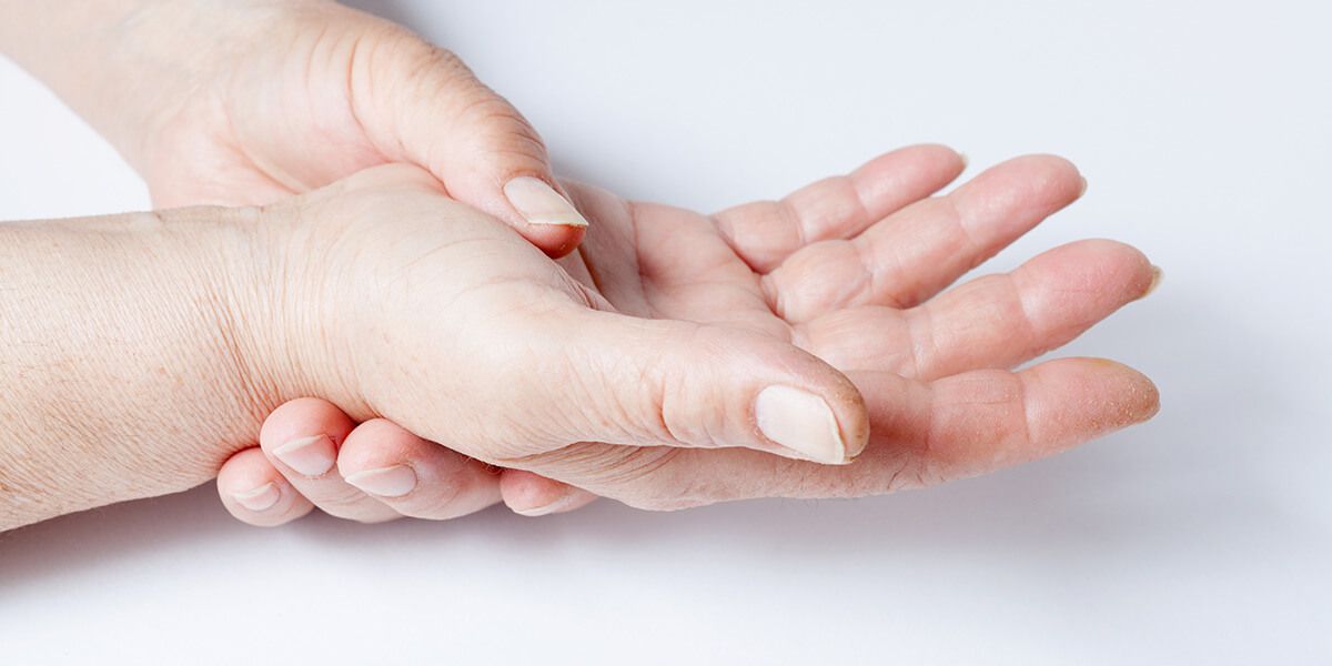 The woman holds her right palm with her left hand