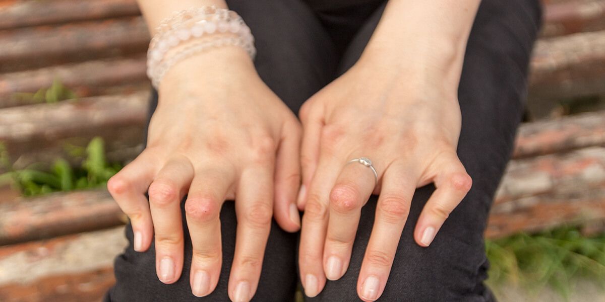 The woman's hands with the ring clenched tightly in her lap